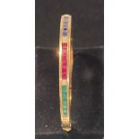AN 18CT YELLOW GOLD BANGLE set with sapphire, rubies, emeralds and diamonds