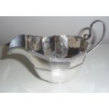 AN EARLY 20TH CENTURY SILVER SAUCE BOAT, Sheffield, 1909, with broad fluted body having reeded rim