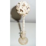 A CHINESE CARVED IVORY PUZZLE BALL ON STAND, with 5 carved layered balls to the top, the outer