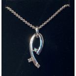 A 9CT WHITE GOLD DIAMOND PENDANT, with three round brilliant cut diamonds in an elegant handmade