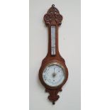 A LATE 19TH CENTURY CARVED OAK ANEROID BAROMETER, with carved frame, 88.9cm x 26.6cm x 7cm (HxWxD)