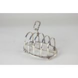 A Victorian silver toast rack, four divisions and central handle on oval frame base with ball