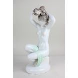 A Herend porcelain figure of a seated female nude arranging her hair, bearing signature "Lux Elek"