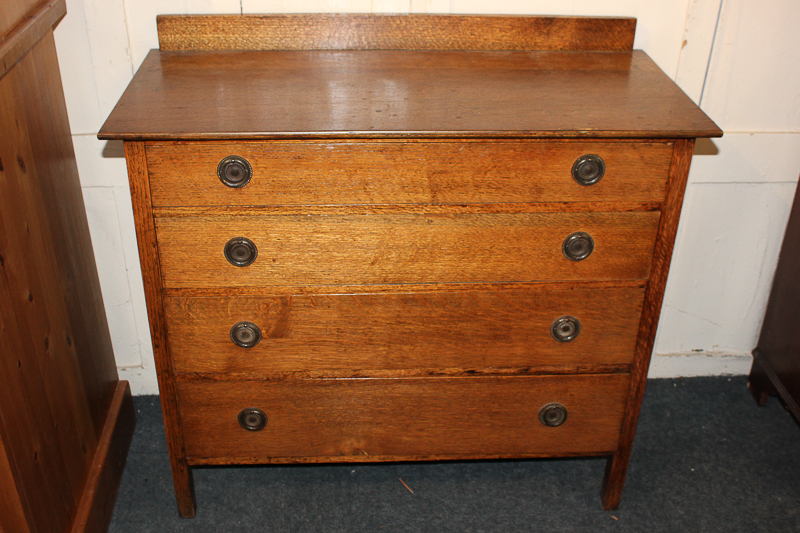 An oak chest of four graduated drawers, with rectangular top, the drawers with circular stamped
