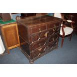 A Jacobean style oak chest of two short over three long drawers with geometric panelled borders, the