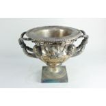 A silver plated two-handled urn decorated in deep relief with classical heads, furs and vines,