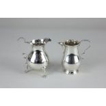 A George III silver cream jug, baluster shape with scroll handle, on three hoof feet, engraved