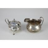 An Edward VII silver mustard pot, circular reeded shape with domed lid and scroll handle, on three