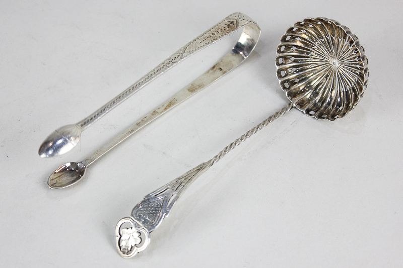 A pair of George III silver sugar tongs, with bright cut engraved decoration, London 1794, and a