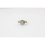 A nine stone diamond cluster ring with pairs of diamonds to each shoulder in 18ct white and yellow