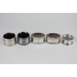 A pair of George V silver mounted napkin rings, engine turned decoration with composite lining,