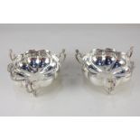 A pair of Victorian silver bonbon dishes, circular scallop form with three scroll handles and