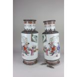 A pair of Chinese porcelain vases, depicting an interior scene of a family welcoming a sage, with
