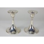 A pair of George V silver candlesticks on flared loaded bases, maker William Aitken, Birmingham