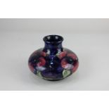 A Moorcroft pottery vase in the pansy pattern on blue ground, WM initial to base, 10cm high