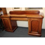 A Victorian mahogany sideboard, the inverted breakfront top with moulded edge, above a frieze drawer