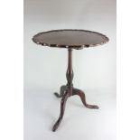 A 19th century mahogany piecrust occasional table with tilt-top, on carved baluster stem to outswept