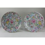 A near pair of Chinese famille rose porcelain chargers, profusely decorated with carnations,