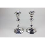 A pair of George V silver candlesticks, baluster shape with removable drip pans, on domed and loaded