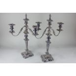 A pair of silver plated three sconce candelabra with embossed floral scrolling design 50cm high