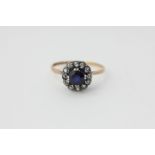 A Swedish sapphire cluster ring the circular stone double claw set within a white sapphire border