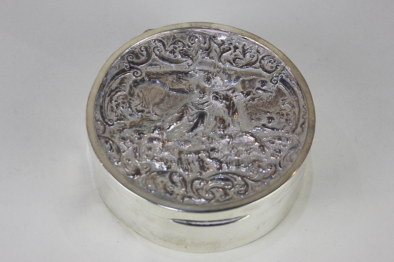 A George V silver circular dressing tale box, maker Andrew Barrett, London 1918, with embossed lid