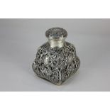 A Victorian silver mounted glass scent bottle, square bombe form with circular hinged lid