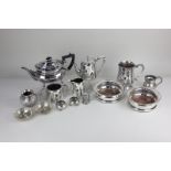 A pair of silver plated bottle coasters, with engraved presentation inscriptions, an oval teapot,