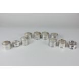 A pair of Edward VII silver napkin rings with foliate engraving, three George V, another pair, and