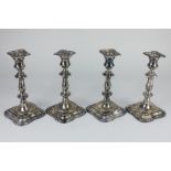 A set of four modern silver candlesticks, baluster shape with detachable nozzles, on square shaped