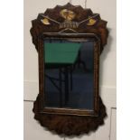 A Queen Anne style wall mirror, the carved frame with gilt helmet and axe crest, the verso