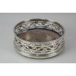 A George III silver bottle coaster with pierced scroll side, engraved initial and wooden base,