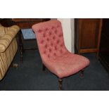 A Victorian pink button upholstered slipper chair, on turned front legs and castors