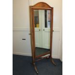 An early 20th century mahogany cheval mirror, on reeded sabre legs, to brass caps and castors,