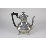 A George V silver tea / coffee pot, baluster shape on four scroll feet, with engraved armorial,