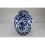 A Chinese blue and white porcelain ginger jar decorated with panels of garden scenes, on blue prunus