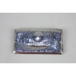 A George V silver card case, rectangular purse shape with spring hinged lid, hammered decoration,