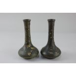 A pair of Japanese Meiji bronze vases depicting a naturalistic scene of a tree with birds and