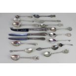 A collection of silver and other metal commemorative teaspoons, including golfing and cities,