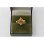 An 18ct yellow gold and ruby ring claw set with a central group of four small rubies on a textured
