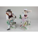 A pair of Sitzendorf porcelain figures modelled as a shepherd and shepherdess, each attending to a