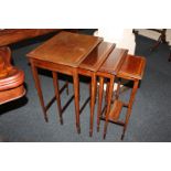 An Edwardian mahogany nest of four side tables, each with rectangular line inlaid top on square