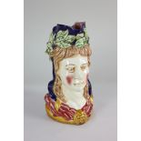 A French pottery large Toby jug modelled as the head and shoulders of a woman wearing laurel crown