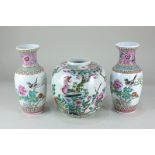 A pair of Chinese porcelain baluster vases, depicting a bird amongst flowers, with character