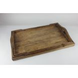 A graduated set of three rectangular wooden trays, each with raised gallery and carry handles,