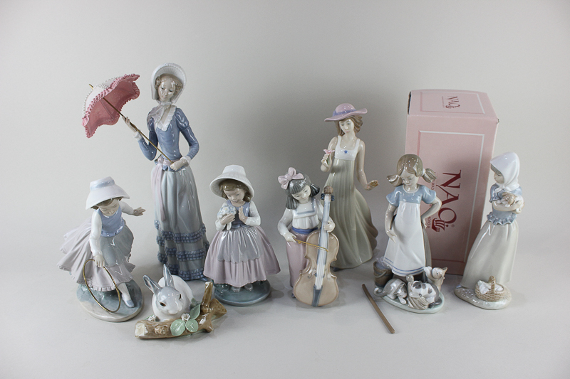 Three Lladro porcelain figures, a woman with a parasol, a girl with a mop and three cats and a