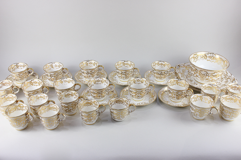 A Victorian porcelain part tea/coffee set, with scrolling gilt decoration on white ground,