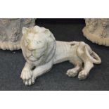 A stone garden ornament of a recumbent lion, 50cm