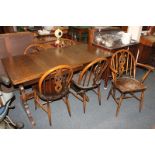 An Ercol type stained oak dining suite, comprising a rectangular dining table on trestle supports,