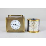 A Jaeger gilt metal alarm clock, cylindrical shape with blue panels and button (glass face damaged),